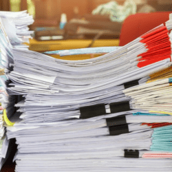 a stack of papers in need of a document management solution for fleets